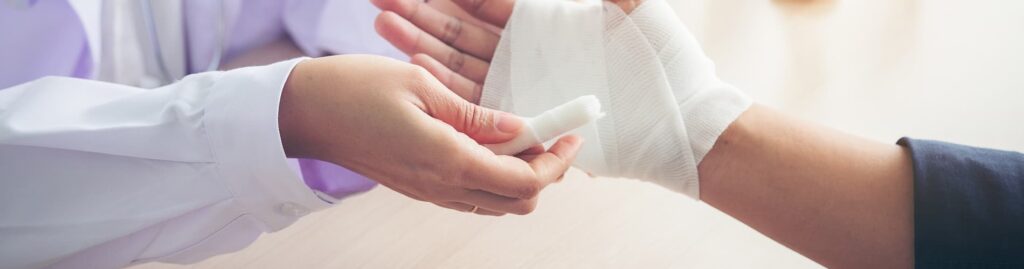 a hand being wrapped in gauze after suffering a severe burn