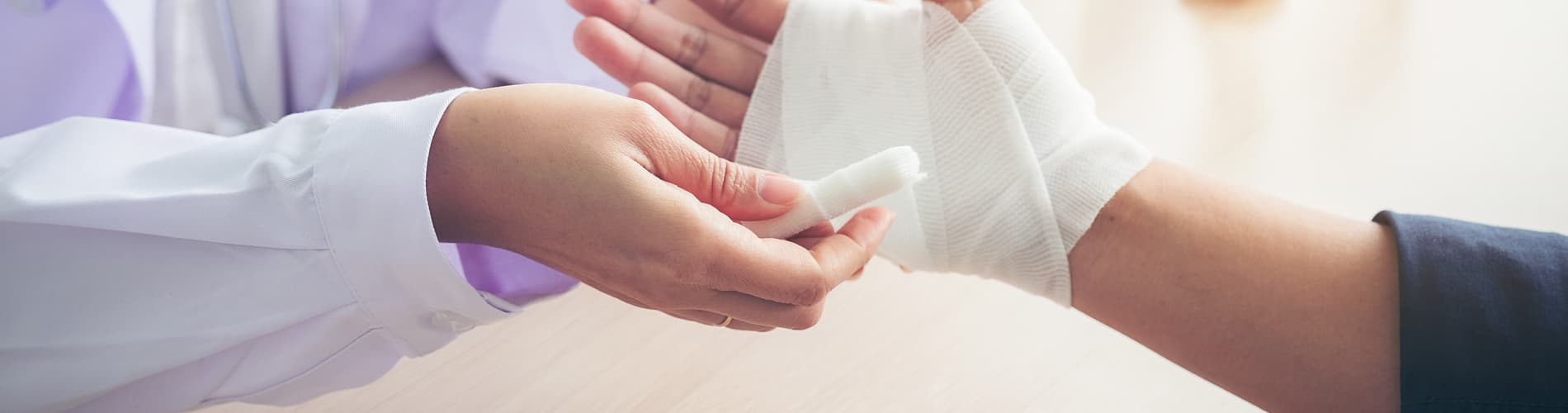 a hand being wrapped in gauze after suffering a severe burn