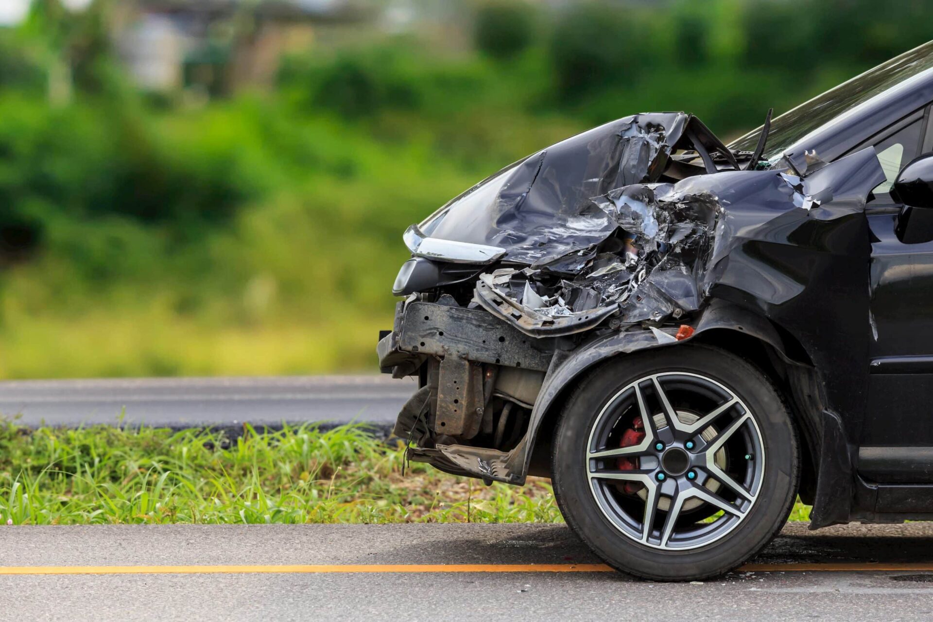 a black car with a smashed hood, presumably from some type of accident
