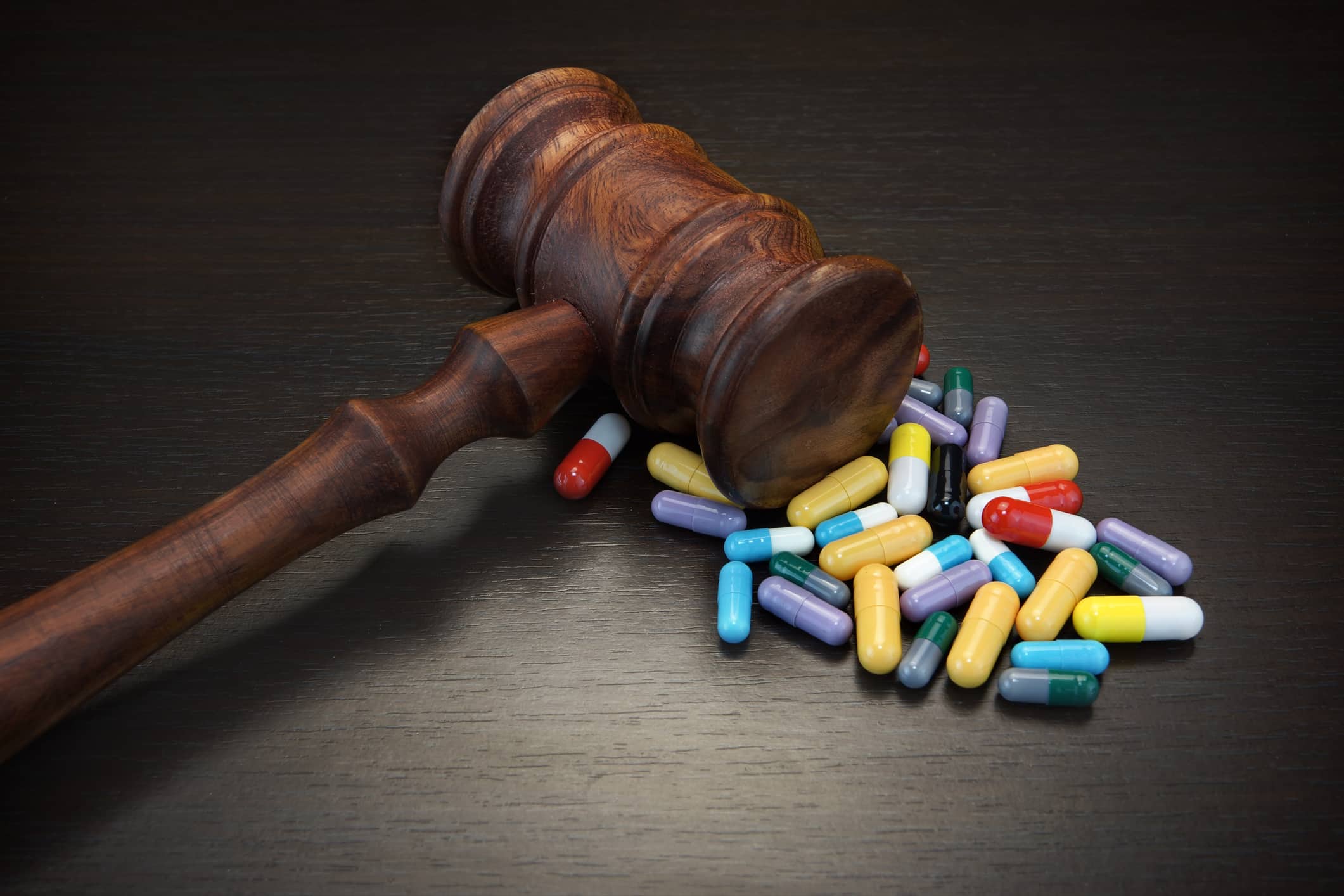 Judges Gavel And Medication On Black Wood Grunge Background, Top View, Close-Up.