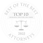A circular badge with the text Best of the Best Attorneys, Top 10 Personal Injury Law Firm, and 2023 surrounding a scale of justice symbol in the center.