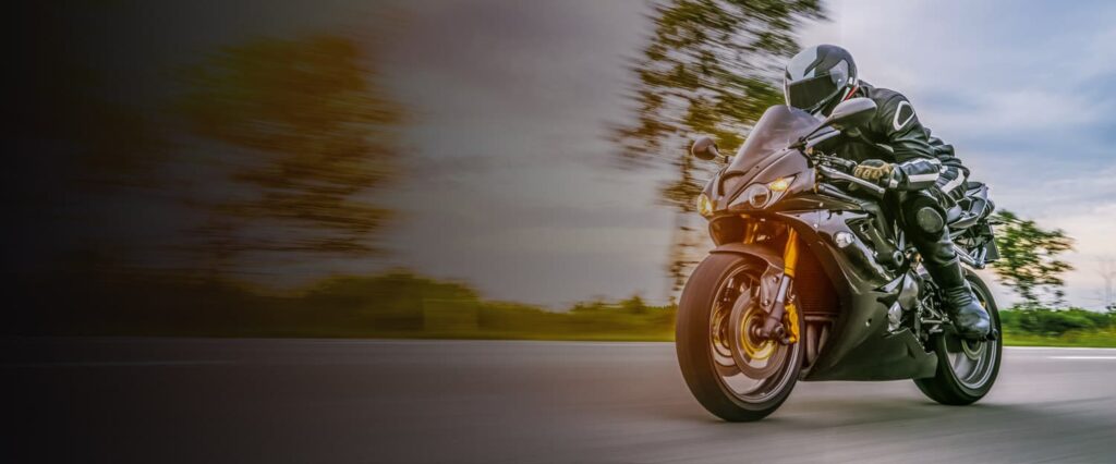 Image of a man riding a motorcycle on the open road