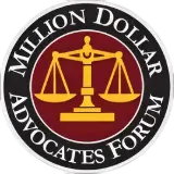 A round logo with a gold balance scale in the center on a maroon background, surrounded by a black border with the words “MILLION DOLLAR ADVOCATES FORUM” in white capital letters.